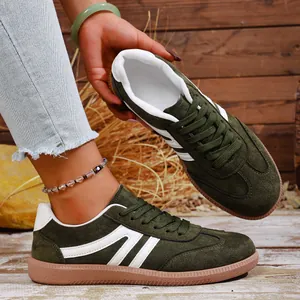 Vintage dark green suede sneakers with retro white stripes and gum sole
