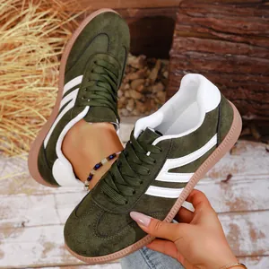 Detail view of retro olive green suede sneakers with white stripes and classic gum sole