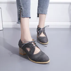 Vue détaillée de chaussures grises de style britannique à talons épais sur pied