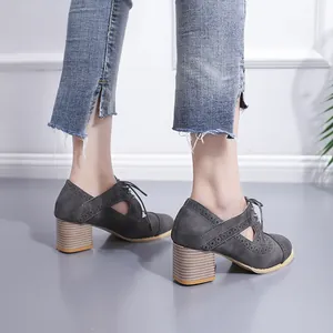 Vue latérale détaillée de chaussures vintage grises à talons épais et motifs ajourés