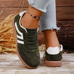 Detail view of retro olive green sneakers with white side stripes and gum sole