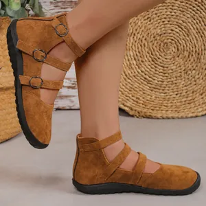 Detailed side view of women's brown suede flat shoes with stylish triple buckle straps