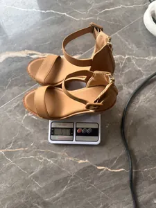 Wedge heel platform sandals being weighed on a digital scale to show weight of 517g