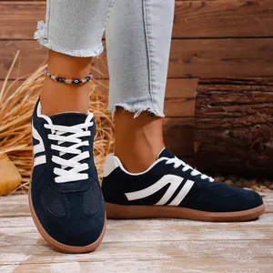 Close-up detail view of navy blue retro sneakers featuring white stripes and gum rubber soles