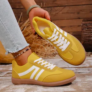 Detailed view of yellow retro casual sneakers with white stripes and gum sole