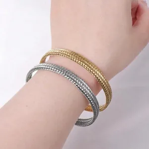 Nahaufnahme von modischen geflochtenen Armreifen aus Edelstahl in Gold und Silber