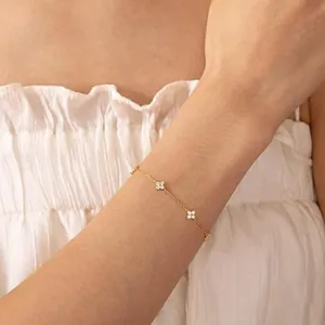 Détail du bracelet élégant en fleurs de zircon plaqué or 18 carats porté au poignet.