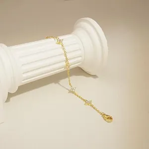 Gros plan d'un bracelet étoile en zircon plaqué or 18 carats sur pilier blanc