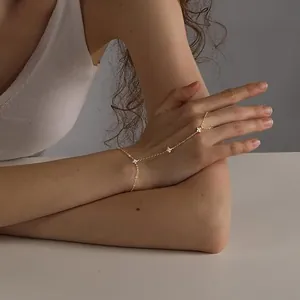 Détail en gros plan du bracelet de main étoilé plaqué or 18K avec zircons pavés