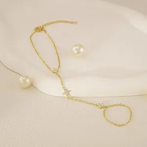 Détail élégant d'un bracelet bague chaîne de main plaqué or 18K avec étoiles en zircon.