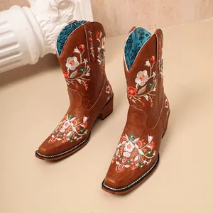 Side view detail of women's brown pointed-toe boots with floral embroidery
