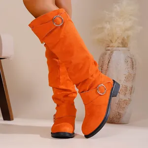 Fashionable orange slouchy over-the-knee boots featuring suede material and buckle detail