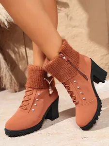 Nahaufnahme brauner High-Heel-Stiefeletten mit Strickbündchen, Reißverschluss und Strass