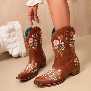 Close-up detail of women's brown western ankle boots with vibrant floral embroidery design