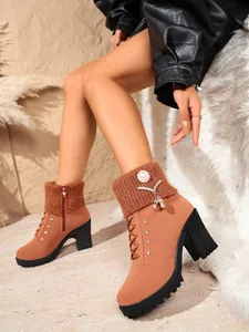 Detailansicht stilvoller brauner Stiefeletten mit hohen Absätzen und Strickbündchen