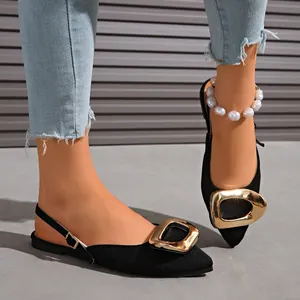Elegant black pointed-toe flat sandals with a large gold buckle and slingback strap.