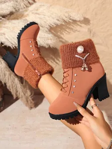 Detailansicht der braunen Mode-Stiefelette mit Strickkragen und elegantem Perlen-Anhänger