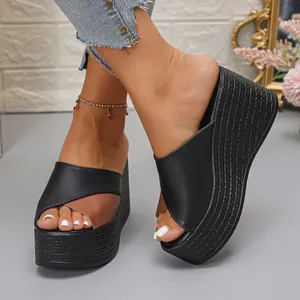 Close-up van dames wedge plateau sandalen met zwart en bruin patchwork lederen look