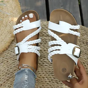 Detailansicht weißer geflochtener Sandalen auf einem rustikalen Strohmattengrund