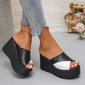 Detailopname van modieuze zwart-witte platform slippers met sleehak voor dames model