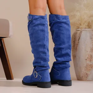 Close-up detail of blue slouchy suede knee-high boots with silver buckle accent.