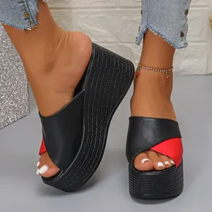 Gedetailleerd overzicht van stijlvolle zwart-rode wedge-platform slippers aan modelvoeten