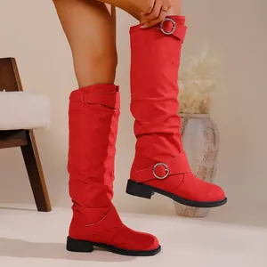 Detailed view of stylish red slouchy high boots with buckle detail worn by a fashion model