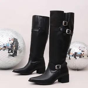 Detailed view of black knee-high boots featuring silver buckle straps and a block heel