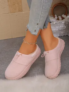 Close-up of pink suede fleece-lined mules with thick sole and drawstring detail for winter