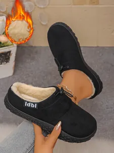 Detail of black fleece-lined slip-on mules with plush interior and warm flame graphic