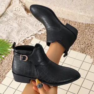 Detailed view of black crocodile pattern western ankle boots with side buckle detail