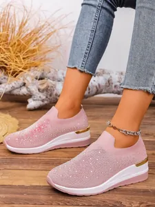Detailed view of pink fly-woven slip-on wedge sneakers decorated with sparkly rhinestones