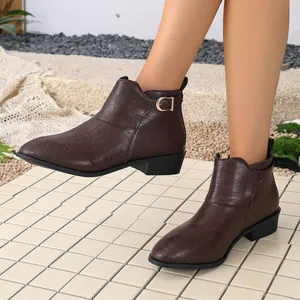 Close-up detail of brown crocodile textured women's ankle boots with side buckle.