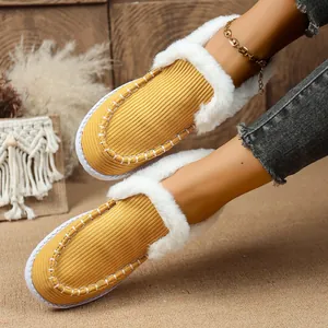 Detail von gelben Cord-Loafers für Damen mit weißem Kunstfellfutter und Ziernähten
