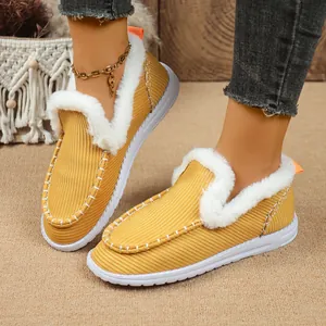 Detailaufnahme gelber Cord-Loafer mit weißem Kunstfellfutter und feinen Ziernähten.
