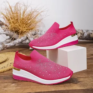 Detailed view of pink rhinestone wedge sneakers with breathable knit fabric and gold trim