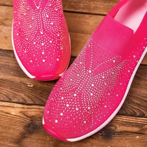 Detail view of hot pink flying woven shoes with sparkling rhinestone butterfly pattern.