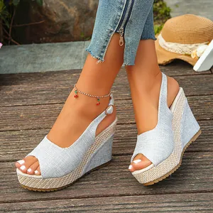 Detail shot of summer light blue linen wedge sandals featuring a woven platform and peep-toe