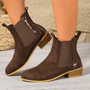 Detailed view of women's brown Chelsea boots with crocodile texture and suede finish