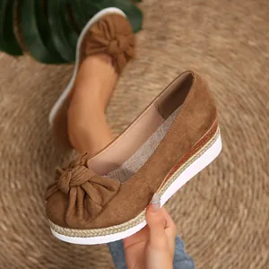 Κοντινό πλάνο καφέ σουέτ loafers με πλατφόρμα, φιόγκο και σόλα στυλ εσπαντρίγιας