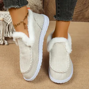 Detailaufnahme von beigen Stoff-Loafers mit weißem Kunstpelzfutter und Gummisohlen.