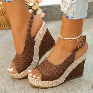 Detailed view of brown linen wedge peep-toe sandals with platform sole worn on feet.