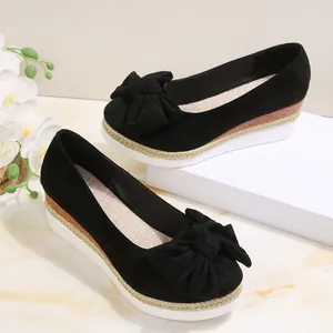 Λεπτομέρεια από μαύρα σουέντ loafers με διακοσμητικό φιόγκο και χοντρή σφήνα σόλα