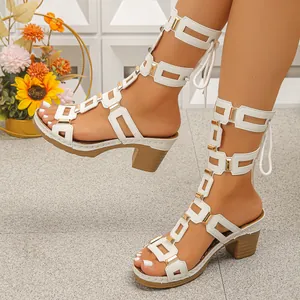 Elegant white gladiator sandals with block heel and decorative gold hardware accents