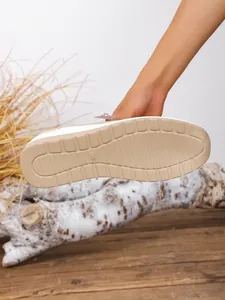 Detail view of the anti-slip tan sole on these stylish women's wedge fly-knit sneakers