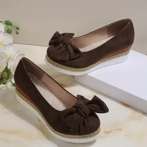 Λεπτομέρεια από καφέ καστόρινα loafers με πλατφόρμα, μεγάλο φιόγκο και λευκή σόλα