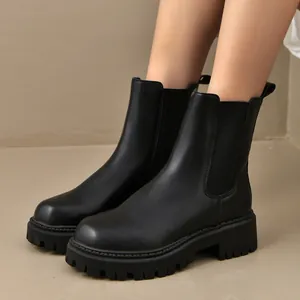 Vue détaillée de bottines Chelsea noires à semelle plateforme et panneaux élastiques.