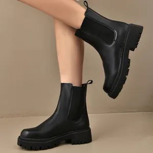 Détail de bottines Chelsea noires à plateforme avec semelles crantées et côtés élastiques.