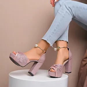 Zoom sur des sandales roses à paillettes avec nœud et bride perle à la cheville.