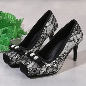 Nahaufnahme von schwarzen Spitzen-High-Heels mit elegantem Strass-Schleifen-Detail am eckigen Zeh.